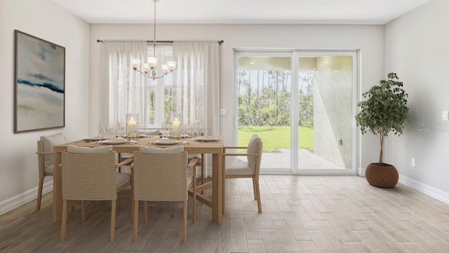 dining area with light wood-type flooring and an inviting chandelier