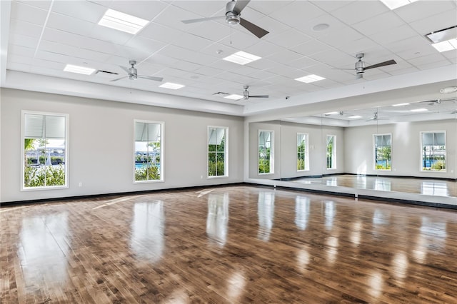 workout room with wood finished floors, a wealth of natural light, and baseboards