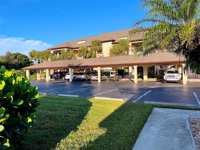 view of car parking with a lawn and a carport