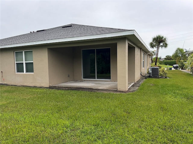 back of house featuring a yard, central AC, and a patio area