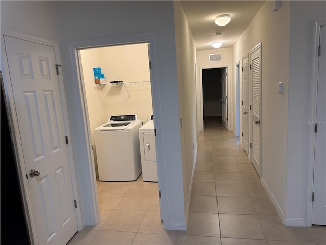 hall featuring light tile patterned floors and washer and dryer