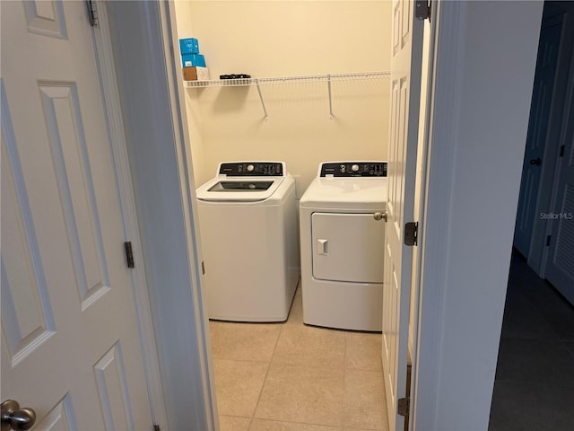 clothes washing area with light tile patterned floors and independent washer and dryer