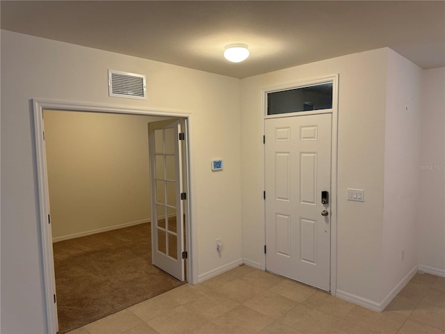 foyer entrance featuring light carpet