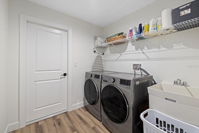 laundry area with washer and dryer, hardwood / wood-style floors, and sink