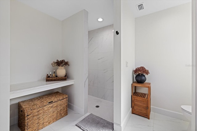 bathroom with toilet and a tile shower