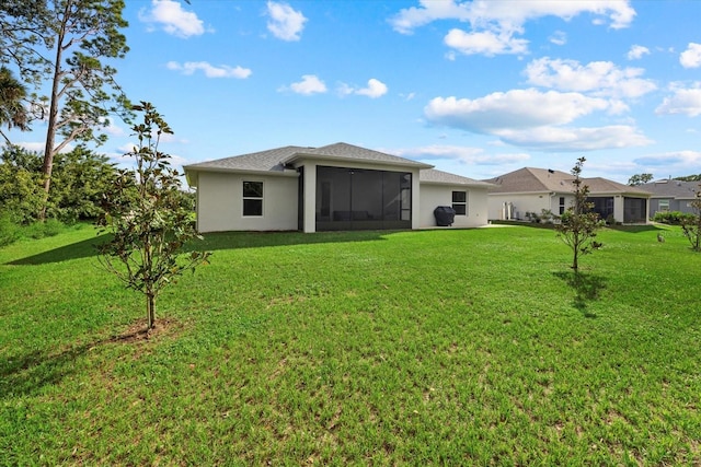 back of house with a sunroom and a lawn