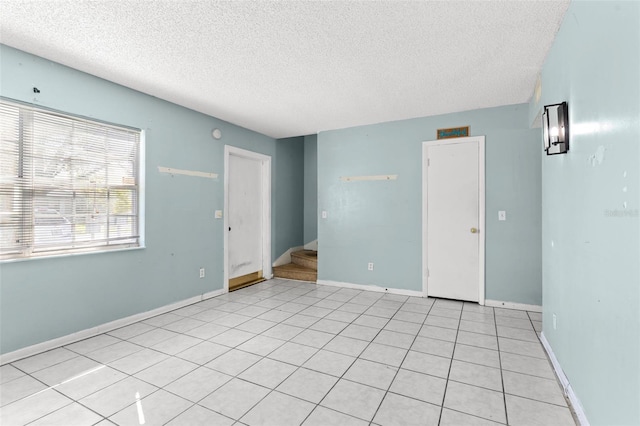 tiled spare room with a textured ceiling