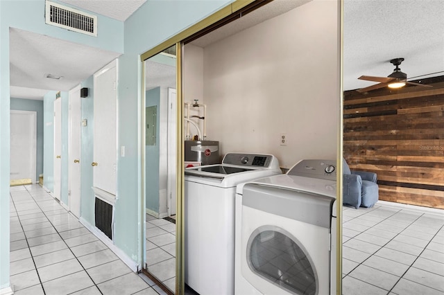 washroom featuring light tile patterned floors, ceiling fan, a textured ceiling, water heater, and washing machine and dryer