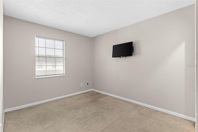 empty room with light carpet and a textured ceiling