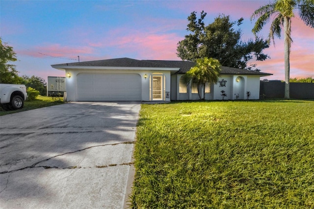 ranch-style house featuring a lawn and a garage