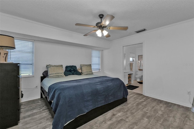 bedroom with ceiling fan, ensuite bathroom, hardwood / wood-style floors, crown molding, and a textured ceiling