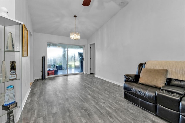 living room with ceiling fan with notable chandelier, wood-type flooring, and vaulted ceiling