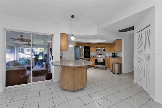 kitchen with light stone countertops, kitchen peninsula, decorative light fixtures, light tile patterned floors, and appliances with stainless steel finishes