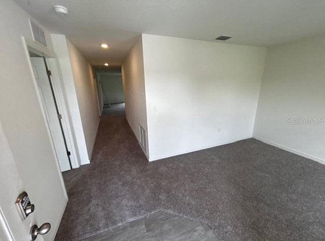 spare room featuring dark colored carpet