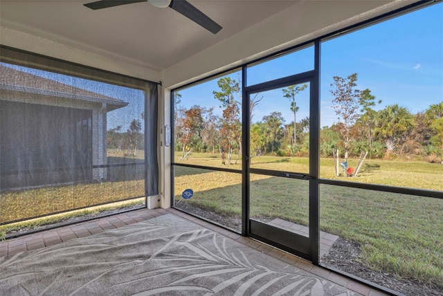 unfurnished sunroom featuring ceiling fan