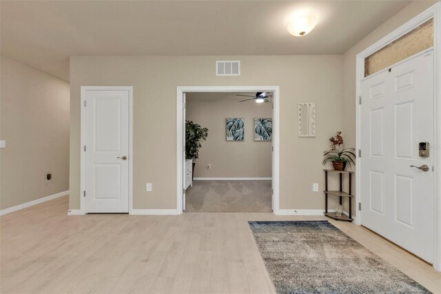 foyer with ceiling fan and light hardwood / wood-style flooring