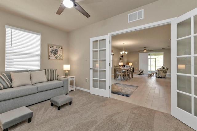 living room with french doors, carpet flooring, and ceiling fan