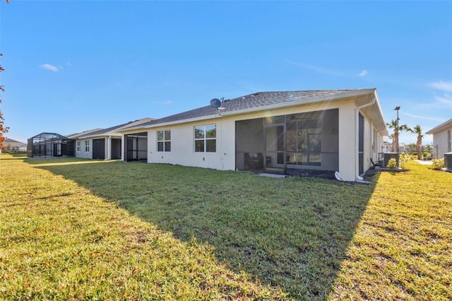 back of property with a sunroom and a lawn