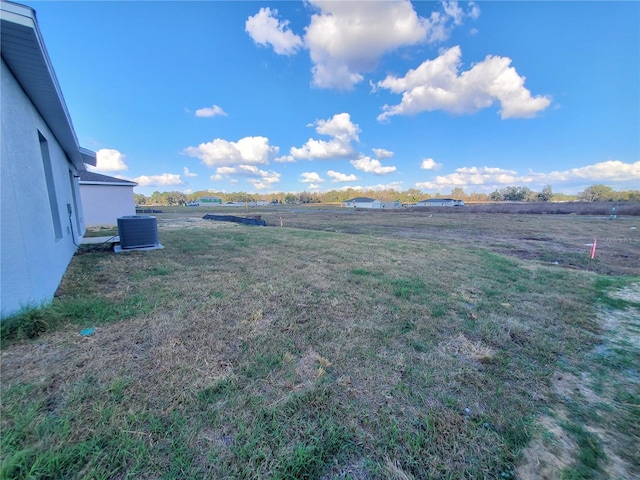 view of yard featuring central air condition unit and a rural view