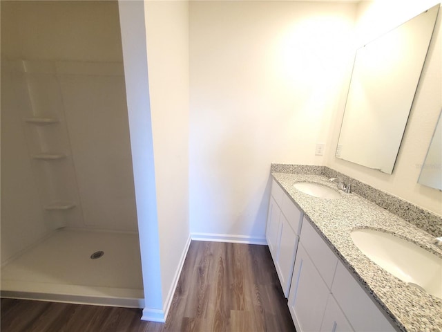 bathroom with a shower, hardwood / wood-style flooring, and vanity