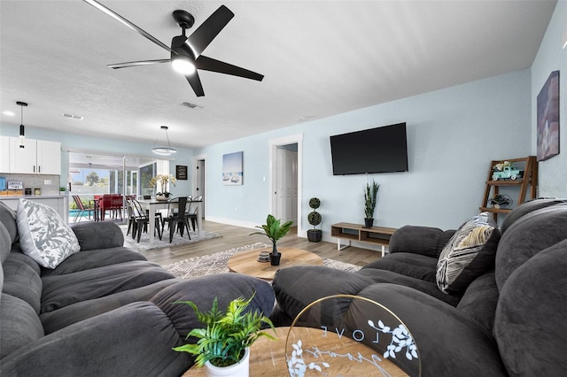 living room featuring light hardwood / wood-style flooring and ceiling fan