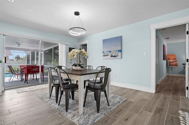 dining area featuring a textured ceiling and hardwood / wood-style floors