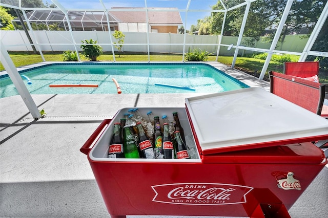 view of pool with glass enclosure and a patio