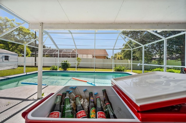 view of swimming pool featuring a lanai, a storage shed, a patio area, and a yard