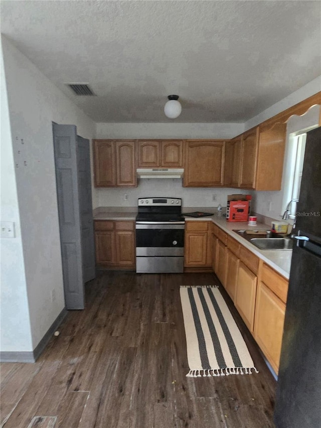 kitchen with dark wood-type flooring, sink, black fridge, stainless steel electric range, and a textured ceiling