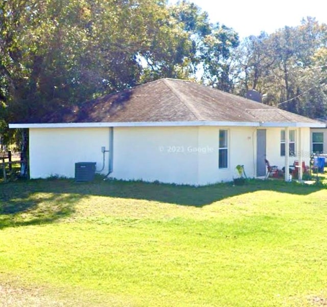 back of house with a lawn and central AC