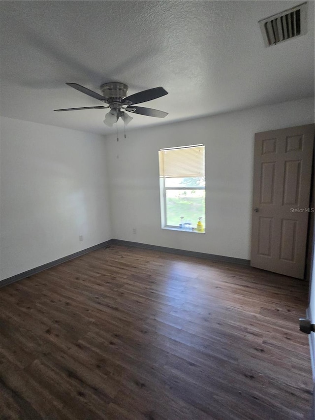 unfurnished room with dark wood-type flooring, ceiling fan, and a textured ceiling