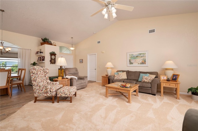 living room featuring light hardwood / wood-style floors, lofted ceiling, and ceiling fan with notable chandelier