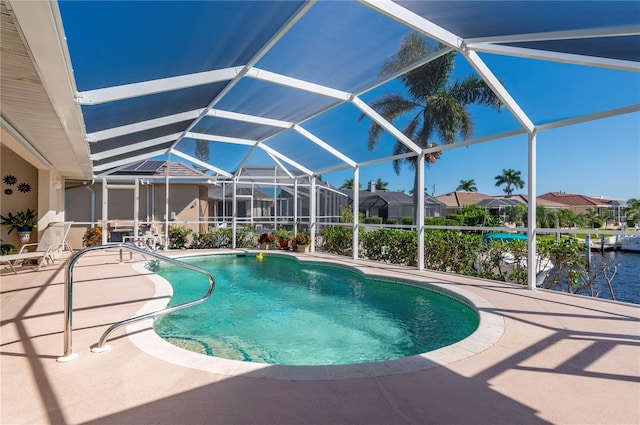 view of swimming pool with a patio area, a water view, and glass enclosure