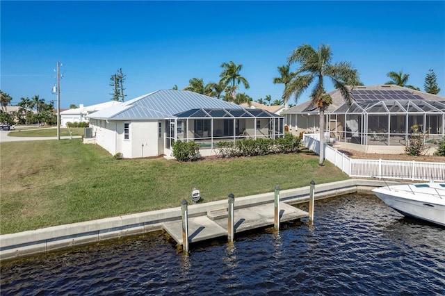 dock area featuring a lawn, a water view, and glass enclosure