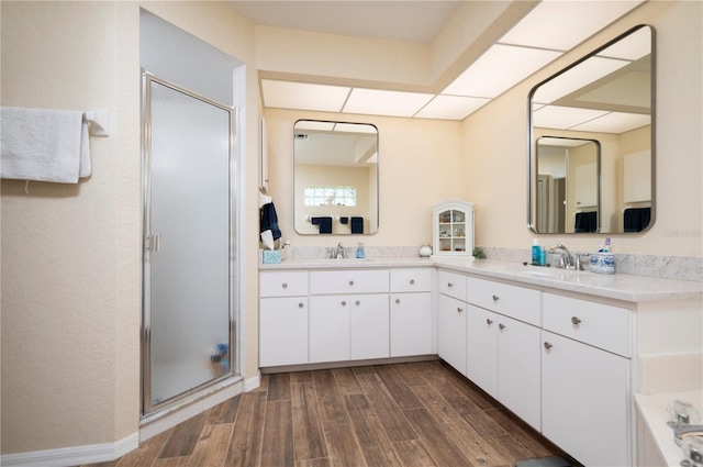 bathroom with vanity, wood-type flooring, and plus walk in shower