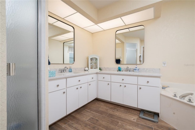 bathroom featuring vanity, hardwood / wood-style floors, and plus walk in shower