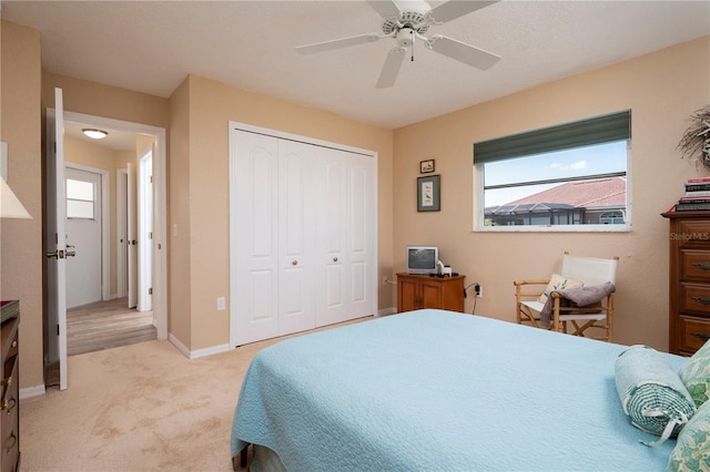 carpeted bedroom featuring a closet and ceiling fan