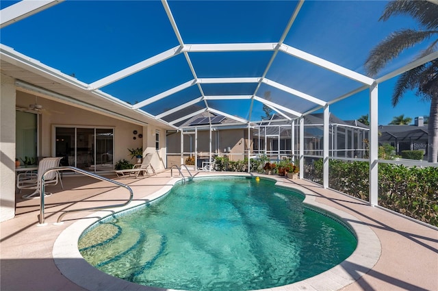 view of swimming pool featuring a patio and glass enclosure