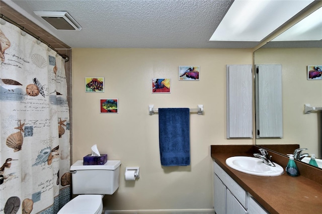 bathroom featuring vanity, toilet, a textured ceiling, and walk in shower