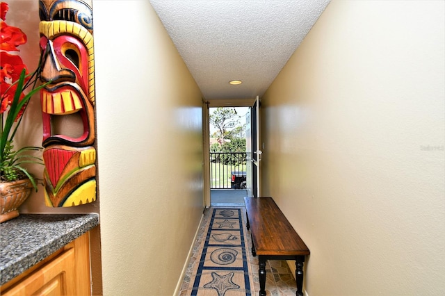 corridor with a textured ceiling and tile patterned floors