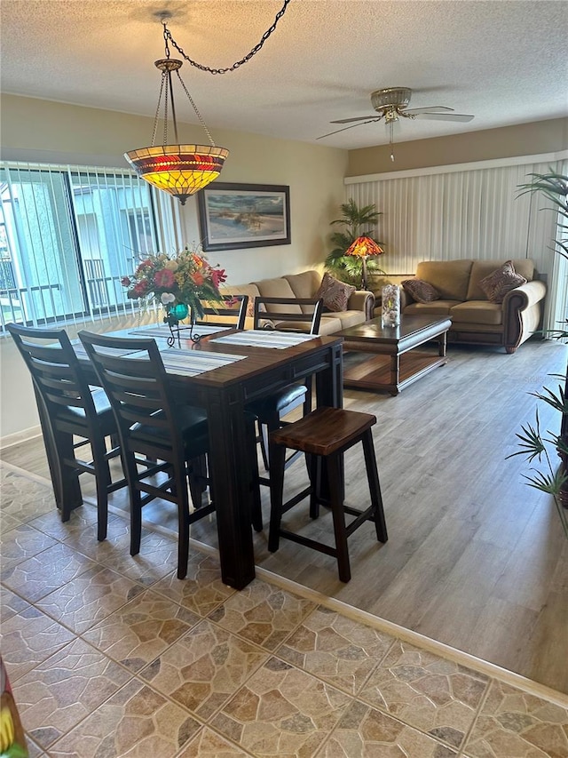 dining area featuring a textured ceiling, hardwood / wood-style flooring, and ceiling fan