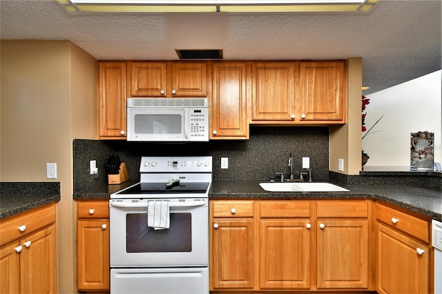 kitchen featuring sink, decorative backsplash, a textured ceiling, and white appliances