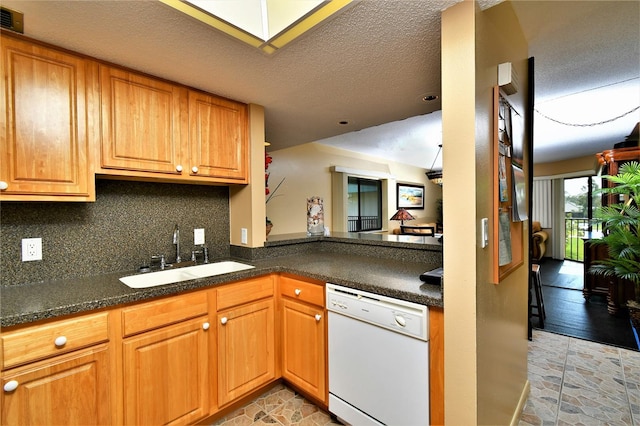 kitchen with decorative backsplash, sink, white dishwasher, and a textured ceiling