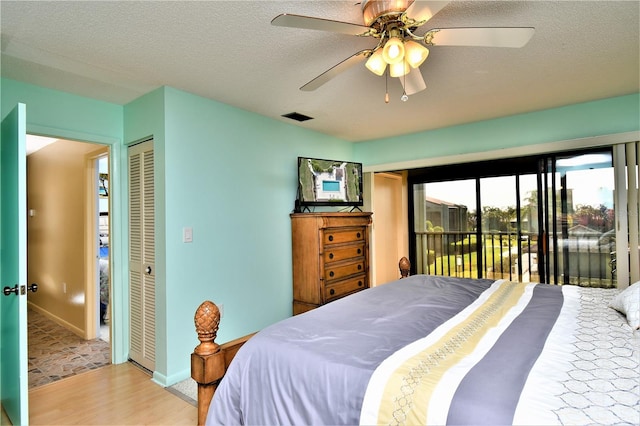 bedroom featuring light wood-type flooring, a textured ceiling, access to exterior, a closet, and ceiling fan