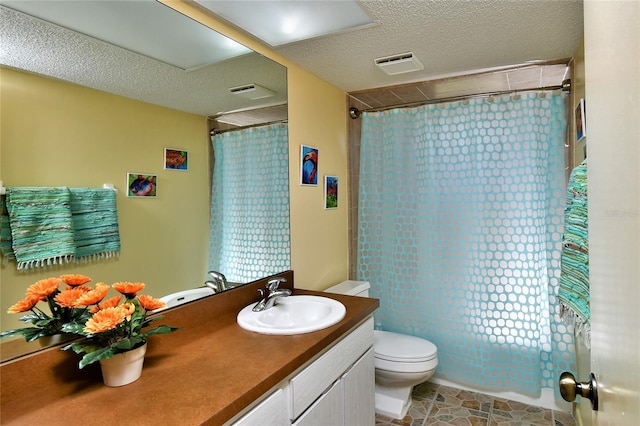 bathroom with toilet, a textured ceiling, vanity, and tile patterned flooring