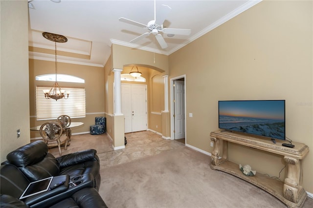 carpeted living room with ornamental molding, ornate columns, and ceiling fan with notable chandelier