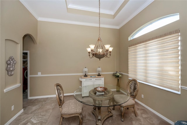 dining room featuring ornamental molding, a notable chandelier, and a tray ceiling