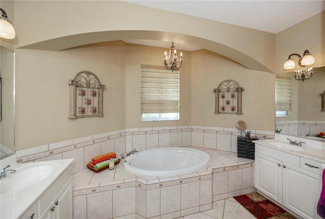 bathroom with vanity, a notable chandelier, tiled bath, and tile patterned flooring