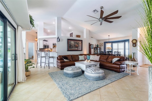 tiled living room with ceiling fan and high vaulted ceiling