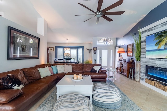 living room with lofted ceiling, ceiling fan, and light tile patterned floors